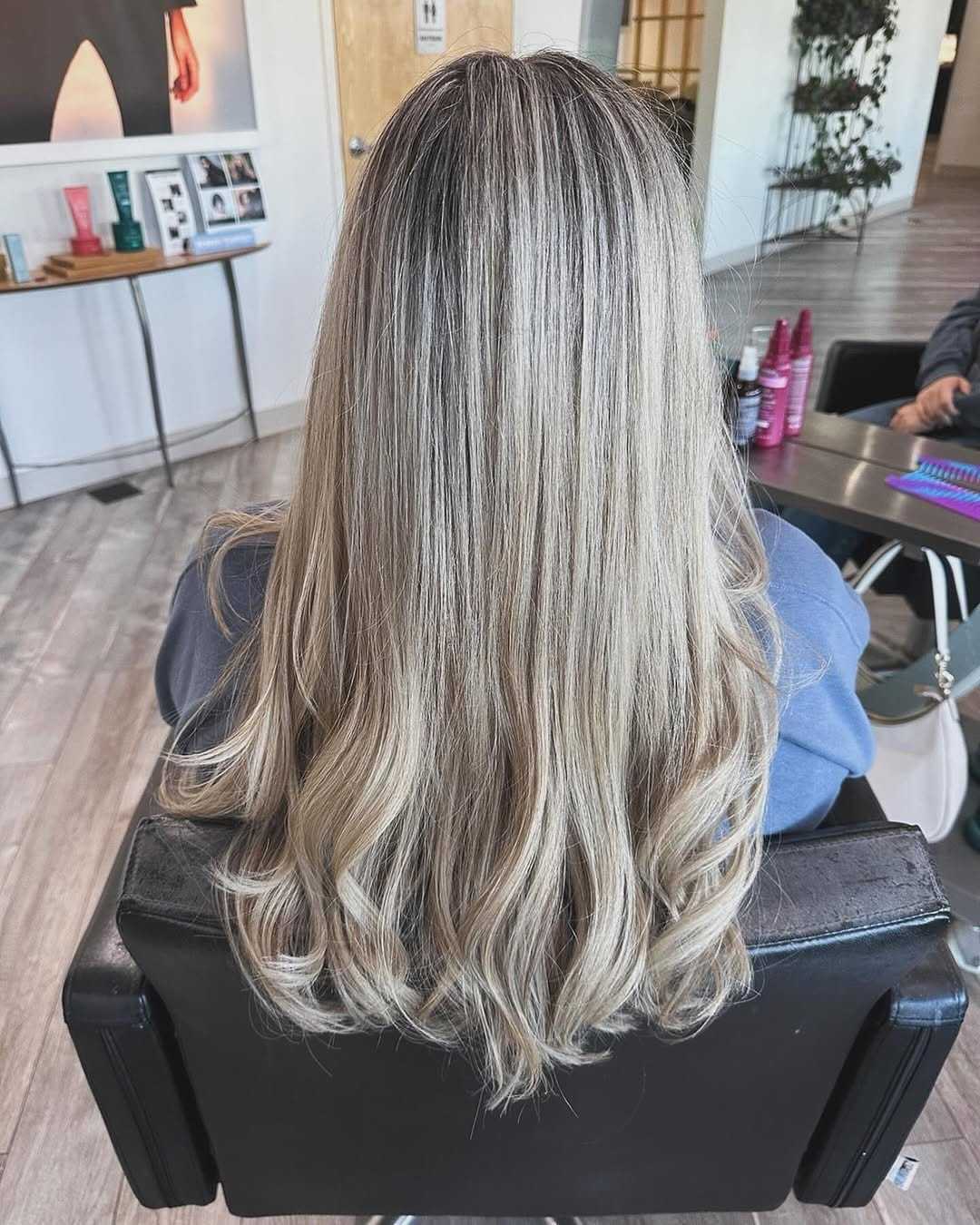 Blonde hair with loose curls in a salon chair, view of the salon interior.